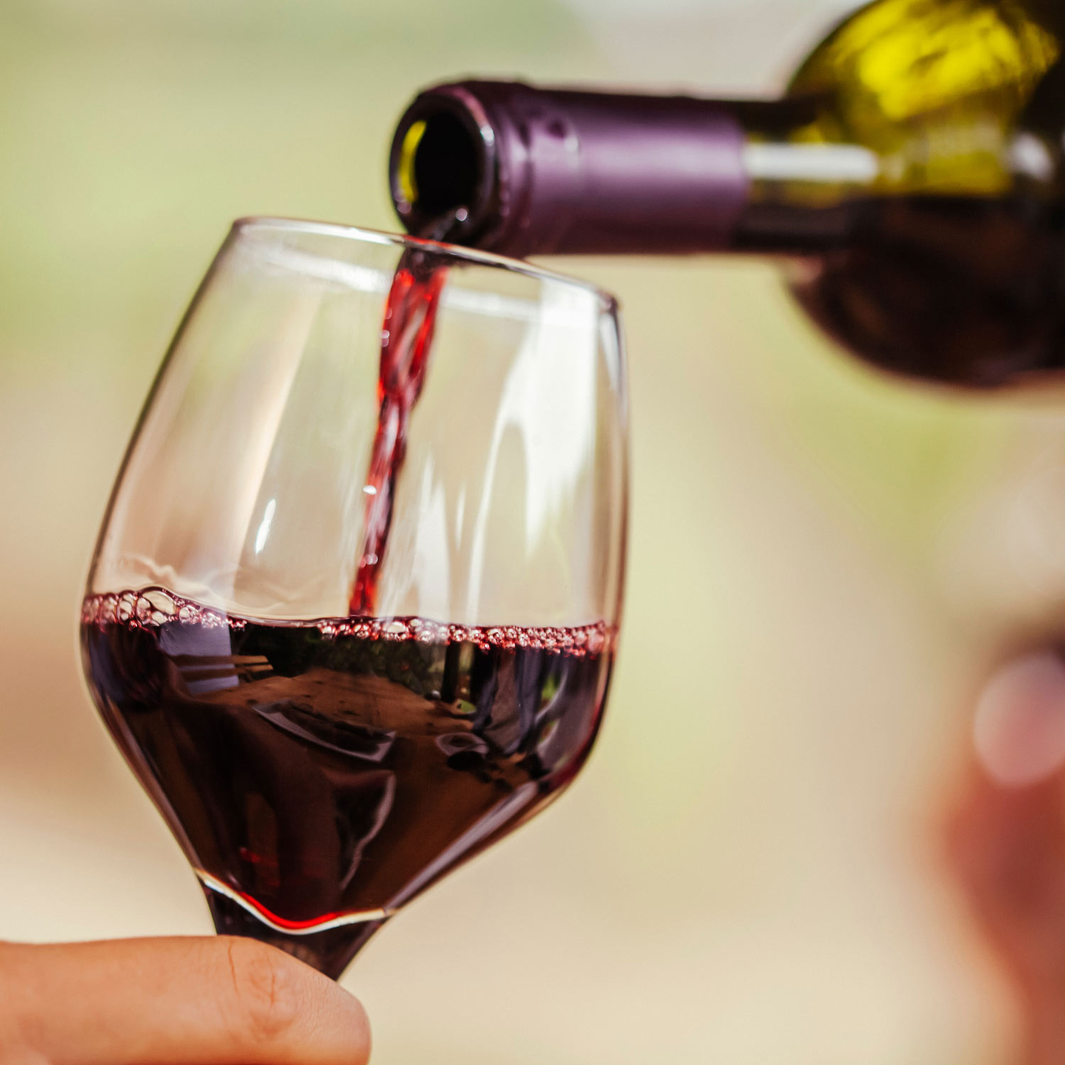 Picture of red wine being poured into a glass.