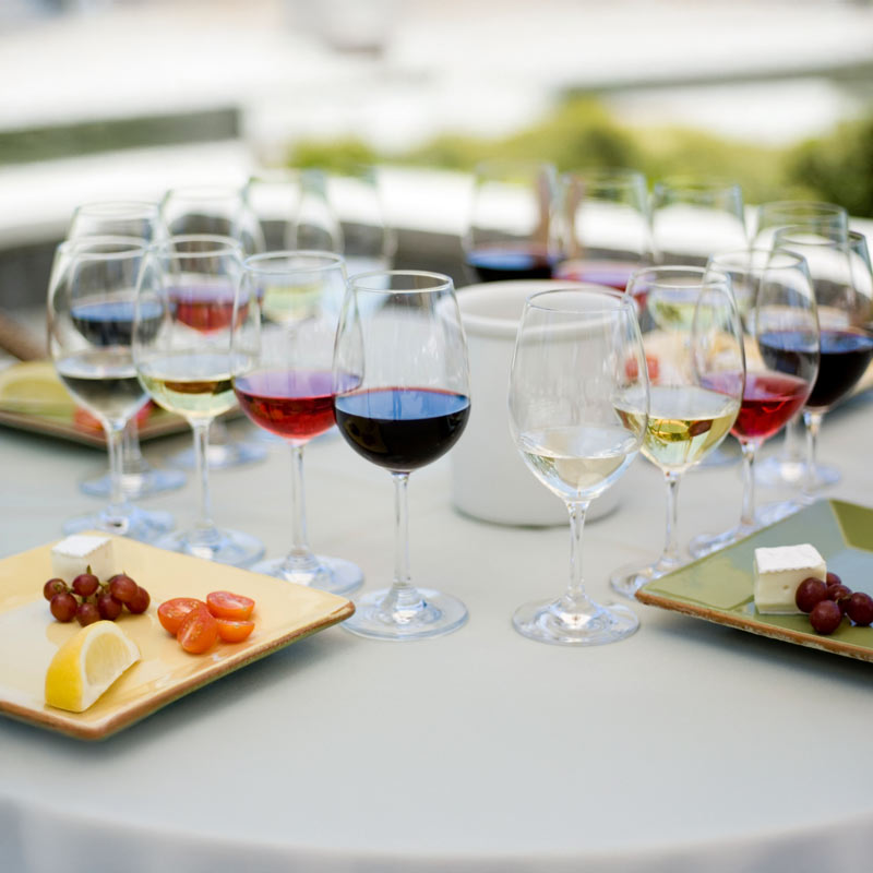 Glasses of wine with fruite and cheese on a table.