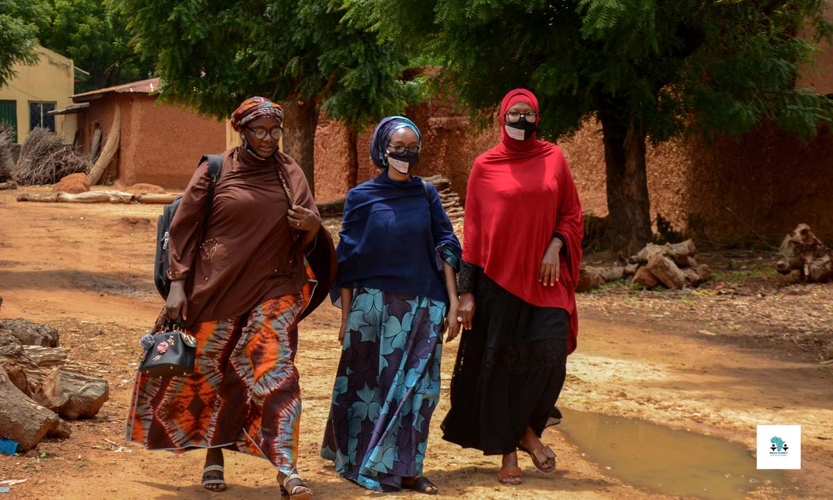  Three girls walking along a road.