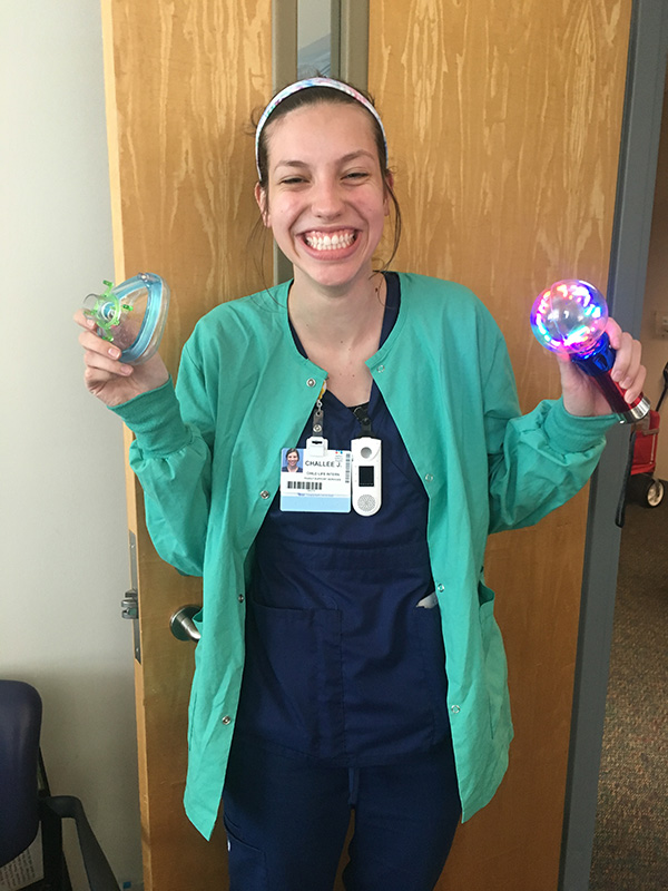 Student holding toys and smiling.